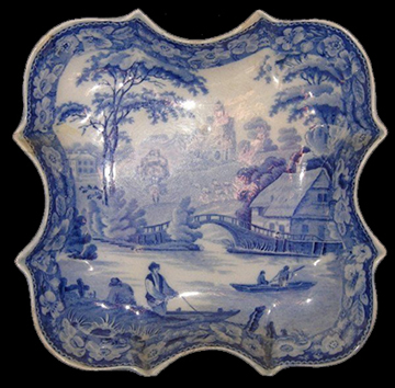 Pearlware saucer printed underglaze in blue. Design based on print entitled “Nuneham Courtenay, Bridge and Cottage”  by S. Owen and published in 1811. Continuous repeating floral border of wild roses. This pattern was used by most major and many minor potteries in the second quarter of the nineteenth century (Coysh and Henrywood 1982, 1989). This design, although based on a print of an actual location, is a better fit in the Pastoral category, for its rural location and fishing theme.